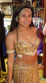 Rowina of the Baltimore Daughters of Rhea Daughters of Rhea Dance Ensemble tries on a gold two piece costume