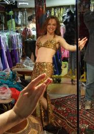 Piper tries on a gold two piece number at Shahrzad's Belly Dance Store