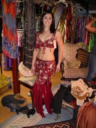 Amelia of the Baltimore Daughters of Rhea Belly Dance Ensemble tries on a red two piece costume